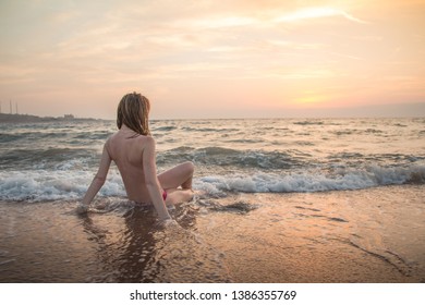 Girl rests and has fun in sea wave at sunset in the evening