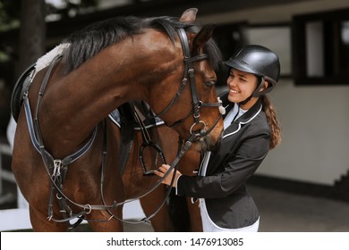 Girl rider adjusts saddle on her horse to take part in horse races. - Powered by Shutterstock