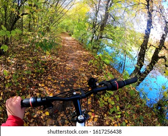 Girl Rides Bicycle Through Forest. Girl Rides Bike Along Path In Forest In Autumn With Sunlight. POV Action Camera Go Pro. Concept Adventure Active Lifestyle Sports. View From First Person Perspective