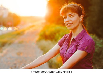 girl rides a bike at sunset