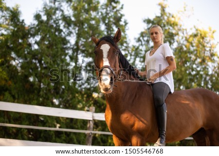 A girl rides a horse on a farm