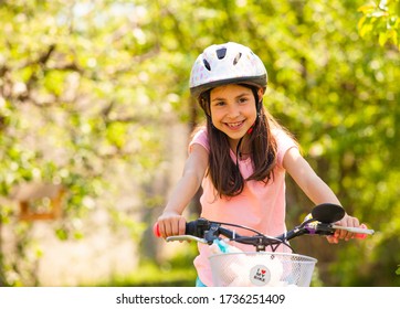 Girl Rides On The Bike With Her Toys In The Basket