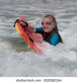 A girl rides on her boogie boarder - Shutterstock ID 2020382264