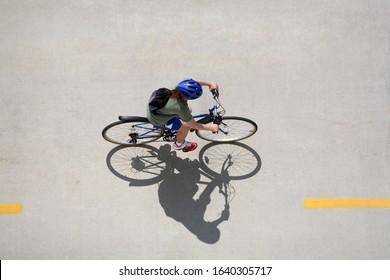 Girl Riding A Bicycle On A Bike Path Taken From Above