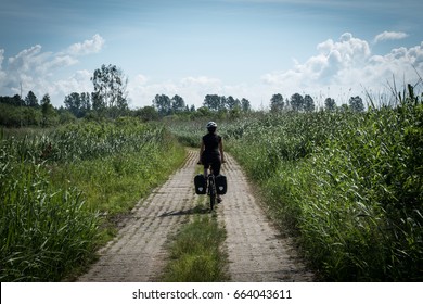 A girl riding bicycle on a bicycle touring trip.