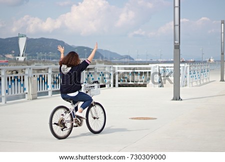 A girl riding a bike with no hands in Yeosu, Korea 