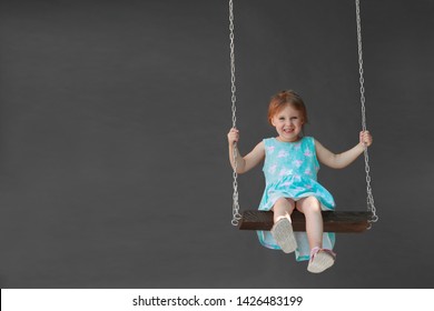 girl riding on a swing outdoors - Shutterstock ID 1426483199
