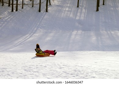 girl riding a tubing from a snow slide