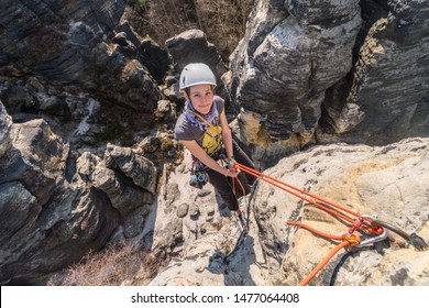 Girl rock climber abseiling from sandstone towers, Tisa sandstone rocks, Usti nad Labem region, Czech republic - Powered by Shutterstock