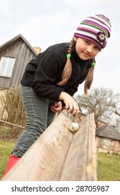 Girl Rolling Colorful Easter Egg Outdoors