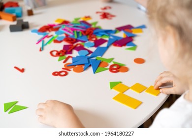 a girl at a round white table plays educational games, a house made of designer children's hands, the concept of development of preschoolers. - Shutterstock ID 1964180227