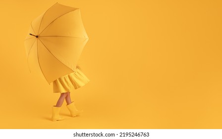 Girl With Rubber Boots For Rain And Umbrella Over Yellow Background