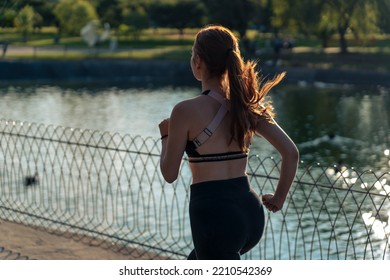 Girl Running Around The Lake In The Park