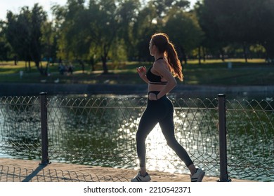 Girl Running Around The Lake In The Park