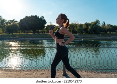 Girl Running Around The Lake In The Park