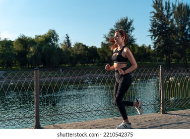 Girl Running Around The Lake In The Park