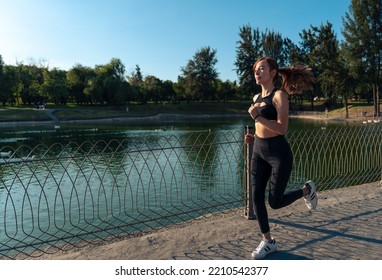 Girl Running Around The Lake In The Park