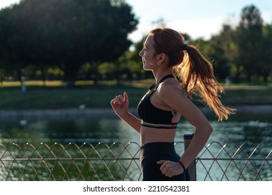 Girl Running Around The Lake In The Park