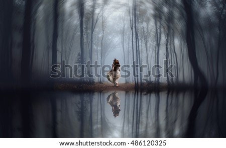  girl running in the middle of a foggy jungle on a winter day
