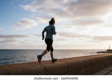 Girl Running Near The Sea, Exercising On A Pier With Sportswear, Backwards