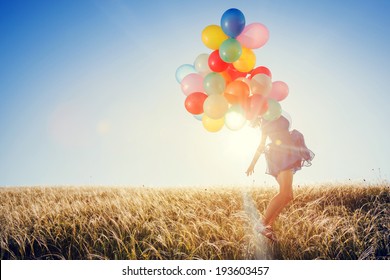 Girl running on the field with balloons at sunset. Happy woman on nature.  - Powered by Shutterstock