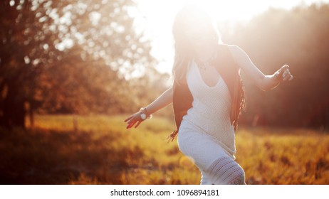 Girl is running out. Young woman in the field, feel freedom and happiness. Casual style.