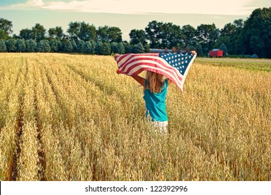 girl running with wheat field with American flag - Powered by Shutterstock