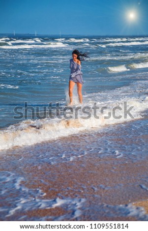 girl runs along the beach in the waves, happy state of mind