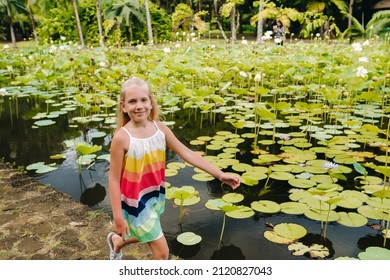 A girl runs in the Botanical Garden on the Paradise island of Mauritius. A beautiful pond with lilies. An island in the Indian Ocean. - Powered by Shutterstock