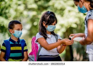 Girl Sanitizing School Child Hands Outdoors