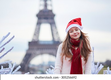 Girl In Santa Hat Near The Eiffel Tower In Paris During Christmas Time