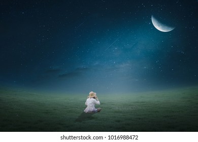 The girl sat in the lawn in the moonlight half moonly.