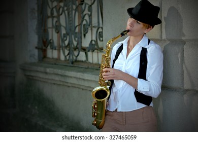 Girl With Saxophone Outside Near The Brick Wall