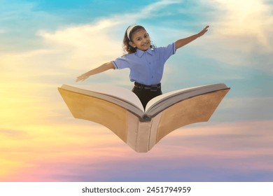 A girl in school uniform flying on book in the sky with open arms - Powered by Shutterstock