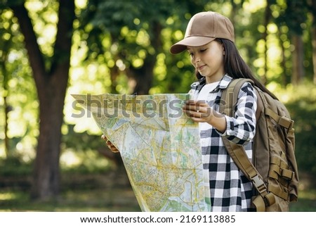 Girl scout walking in woods with map