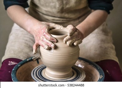 Girl sculpts in clay pot closeup. Modeling clay close-up. Caucasian man making vessel daytime of white clay in fast moving circle. Art, creativity. Ukraine, cultural traditions. Hobbies