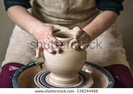 Girl sculpts in clay pot closeup. Modeling clay close-up. Caucasian man making vessel daytime of white clay in fast moving circle. Art, creativity. Ukraine, cultural traditions. Hobbies