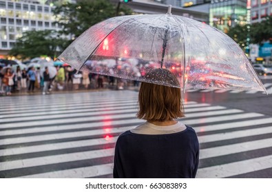 Girl With See Through Umbrella Waiting To Cross A Pedestrian Crossing