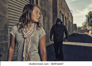 GIRL SELF DEFENSE | A young woman sees a suspicious person walking behind her and plans to defend herself against a male attacker in an alley. Refuse to be a victim.    - Shutterstock ID 304916447