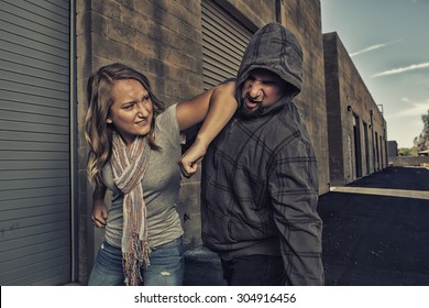 GIRL SELF DEFENSE | A young woman defends herself against a male attacker in an alley by elbowing him in the jaw. Refuse to be a victim.    - Shutterstock ID 304916456