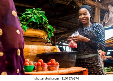 a girl selling tomatoes and vegetables in a typical local african market