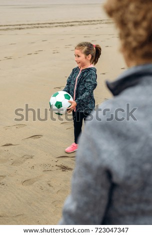 Girl and senior woman playing on the beach