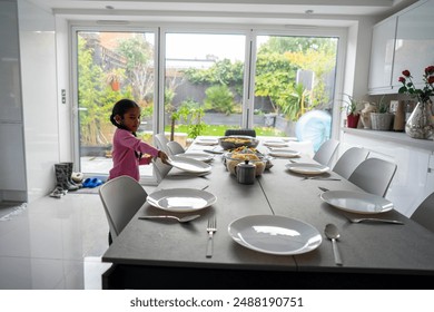 Girl setting table for dinner - Powered by Shutterstock