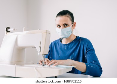 Girl Sews Masks To Protect Against The Corona Virus. Woman Hands Using The Sewing Machine To Sew The Face Medical Mask During The Pandemia. Home Made Diy Protective Mask Against Covid19 Virus.