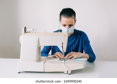 Girl Sews Masks To Protect Against The Corona Virus. Woman Hands Using The Sewing Machine To Sew The Face Medical Mask During The Pandemia. Home Made Diy Protective Mask Against Covid19 Virus.