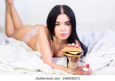 Girl In Sexy Lingerie Eat Burger. Sexual Appetite. Food Delivery Service. Seductive Sexy Woman Relax On Bed. Diet Concept. Fast Food. Seductive Woman Hungry. Lazy Day Food. Eating Junk Food In Bed.