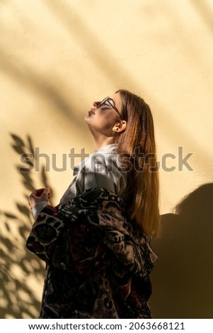 Similar – Kühle blonde Frau mit Sonnenbrille und schwarzem Kleid, die sich bei Sonnenuntergang in der Natur amüsiert.