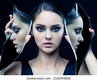 Girl with a shard of the mirror. Female with mirror shard in hand posing on gray background. Face reflection in mirror splinter. Eyes closed.