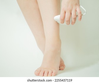 girl shaving her legs with an epilator close-up - Shutterstock ID 2255437119