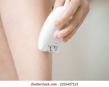 girl shaving her legs with an epilator close-up - Shutterstock ID 2255437121